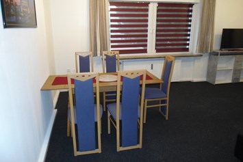 Monteurzimmer: Esstisch mit fünf Stühlen im Gemeinschaftsraum der Monteurunterkunft in Wolfsburg. - BSK-Monteurunterkünfte