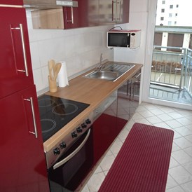 Monteurzimmer: Küche mit Zugang zum Balkon in der Monteurunterkunft in Wolfsburg. - BSK-Monteurunterkünfte