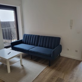 Monteurzimmer: Wohnbereich mit Schlafcouch  - Monteurswohnung TAKAppartement Dormagen EG