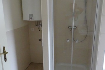 Monteurzimmer: Bad ist ausgestattet mit Dusche, Badewanne, Doppelwaschbecken, Seifenspender, Toilettartikelschrank, Waschmaschine und Wäschetrockner - Refugia Wels