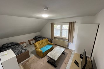 Monteurzimmer: Zimmer 2 / Zweibettzimmer mit 2 Einzelbetten, Couch, Couchtisch und TV. - Monteurzimmer Ferienwohnung Mehrum 