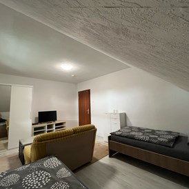 Monteurzimmer: Zimmer 2 / Zweibettzimmer mit 2 Einzelbetten, Couch, Couchtisch und TV. - Monteurzimmer Ferienwohnung Mehrum 