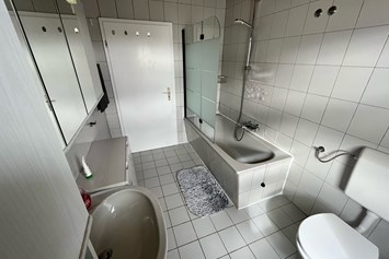 Monteurzimmer: Badezimmer mit Badewanne/Dusche und Toilette - Monteurzimmer Ferienwohnung Mehrum 