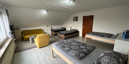 Monteurwohnung - PLZ 31319 (Deutschland) - Zimmer 3 / Vierbettzimmer mit 4 Einzelbetten, Couch, Couchtisch und TV. Zu diesem Zimmer gehört ein Wintergarten mit Blick auf den Garten.  - Monteurzimmer Hohenhameln Mehrum