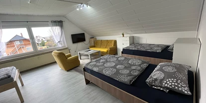 Monteurwohnung - PLZ 31319 (Deutschland) - Zimmer 3 / Vierbettzimmer mit 4 Einzelbetten, Couch, Couchtisch und TV. Zu diesem Zimmer gehört ein Wintergarten mit Blick auf den Garten.  - Monteurzimmer Hohenhameln Mehrum