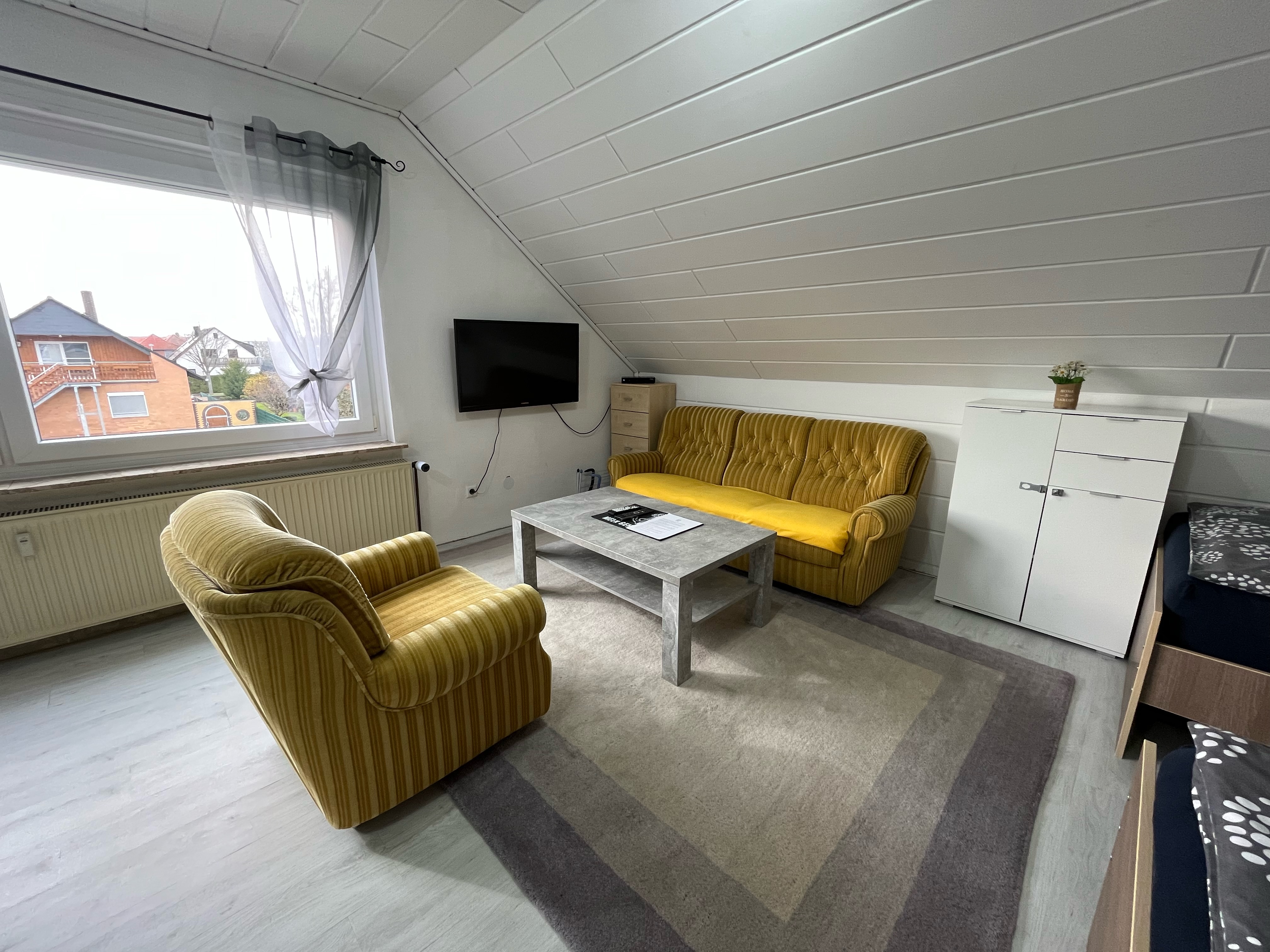 Monteurzimmer: Zimmer 3 / Vierbettzimmer mit 4 Einzelbetten, Couch, Couchtisch und TV. Zu diesem Zimmer gehört ein Wintergarten mit Blick auf den Garten.  - Monteurzimmer Hohenhameln Mehrum 