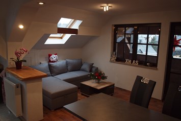 Monteurzimmer: Wohnbereich mit Zugang zum Balkon - Ferienwohnung Rennsteigoase Rosenthal