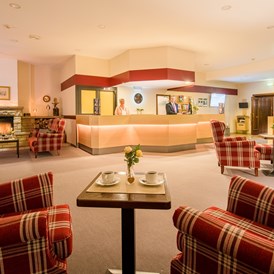 Monteurzimmer: Lobby mit Rezeption, gemütlichen Sitzbereichen und Kaminecke im Waldhotel Schäferberg - Gästehaus Waldeslust 