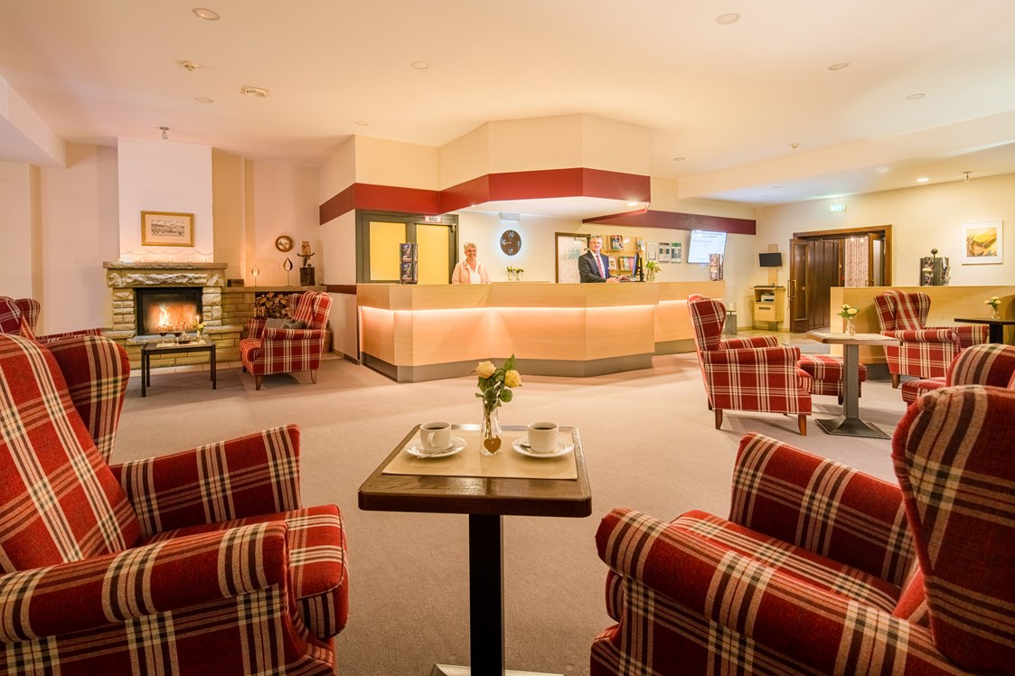 Monteurzimmer: Lobby mit Rezeption, gemütlichen Sitzbereichen und Kaminecke im Waldhotel Schäferberg - Gästehaus Waldeslust 