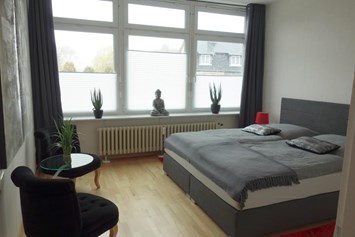 Monteurzimmer: Schlafzimmer mit Boxspringbett und zwei Sesseln - Ferienwohnung 100 qm, Monteurzimmer Uslar im Solling Niedersachsen
