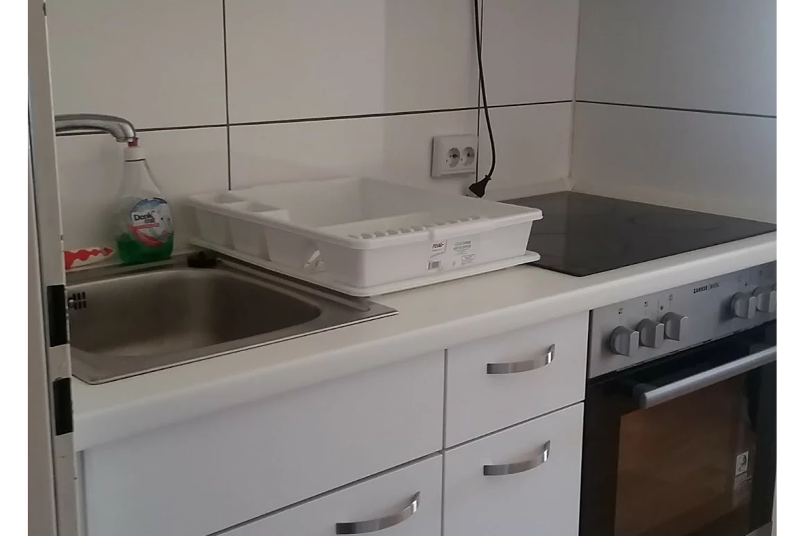 Monteurwohnung: linke Seite der Einbauküche mit Herd und Backofen - Monteurwohnung Rastatt