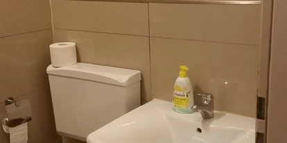 Monteurwohnung - Muggensturm Gaggenau - Toilette, Waschbecken und Spiegel im Badezimmer - Monteurwohnung Rastatt