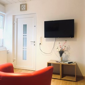 Monteurzimmer: Heller freundlicher TV - Wohnbereich mit Ein - Ausgang der Wohnung - Schlafen wie Zuhause Avianaart Monteur & Ferienwohnung 