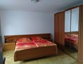 Monteurzimmer: Schlafzimmer mit Doppelbett und Kleiderschrank im Haus Baderup in Oeversee. - Haus Barderup