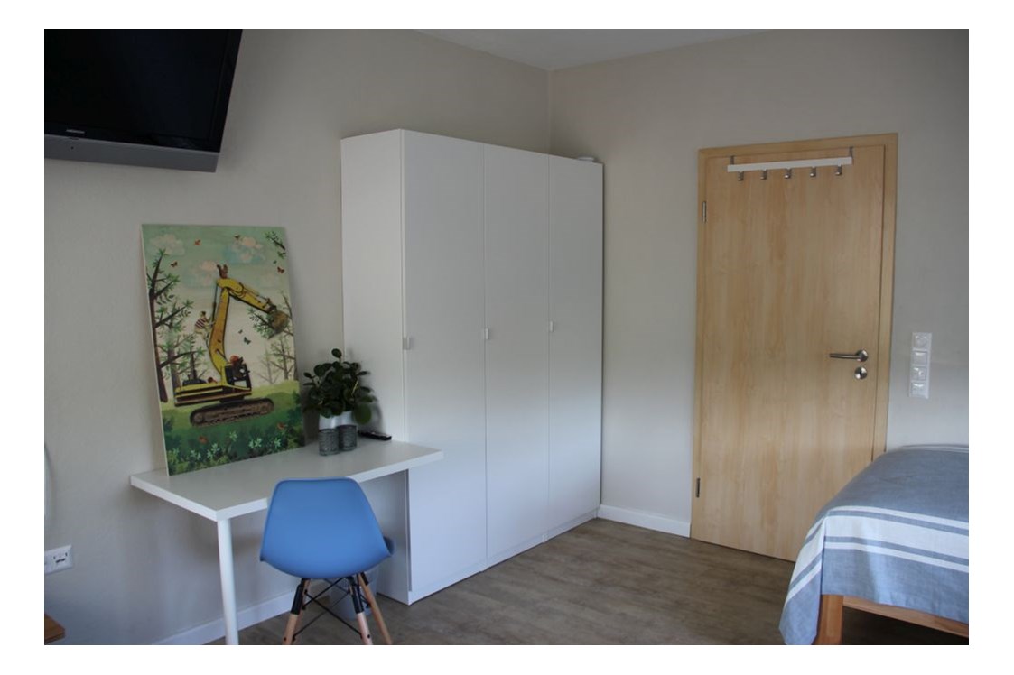 Monteurzimmer: Fernseher, Schreibtisch und Kleiderschränke im Schlafzimmer - Ferienhaus "NaturPur"