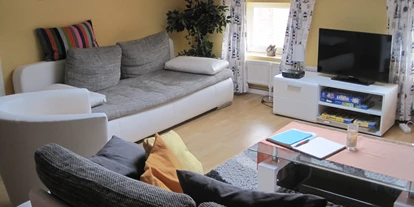 Monteurwohnung - Kaffeemaschine - Schleswig-Holstein - Wohnraum aus Blick der Küche. Die linke Couch lässt sich zusätzlich zum Bett ausziehen - Ferienhof March