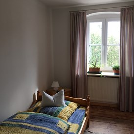 Monteurzimmer: Einzellbett mit seberaten Fernseher 
Zimmer in Richtung Straße  - Zumspatzennest