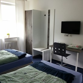 Monteurzimmer: Schlafzimmer mit 2 getrennten  Betten, Schreibtisch, 2 Schränke und TV - Sleep Inn Hagen