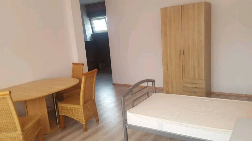 Monteurwohnung - Kaffeemaschine - Neuss - Einzelbett mit Esstisch und Stühlen - Dema