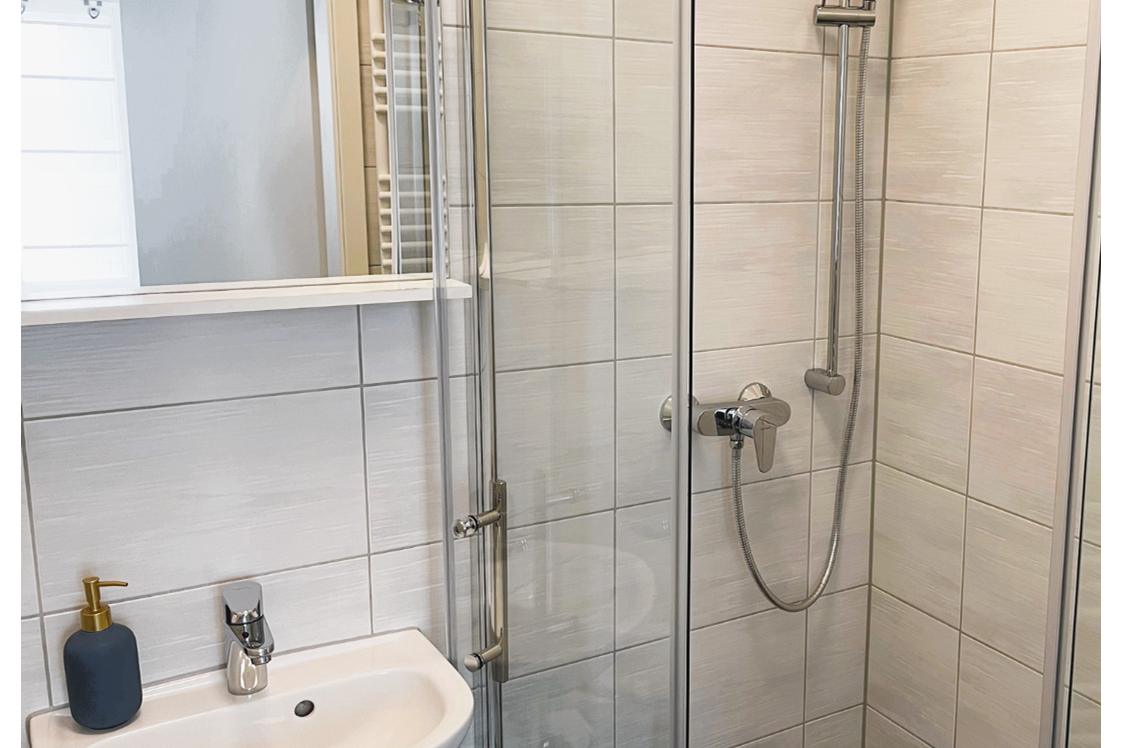 Monteurzimmer: Modernes Badezimmer mit ebenerdiger Dusche, Waschbecken, WC und Waschmaschine. - Apartment Fallersleben 1 in Weimar