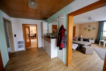 Monteurzimmer: Blick vom Eingangsflur ins Wohnzimmer und Küche,
links Eingangstür Bad - Ferienwohnung Lenk