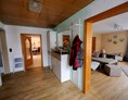 Monteurzimmer: Blick vom Eingangsflur ins Wohnzimmer und Küche,
links Eingangstür Bad - Ferienwohnung Lenk