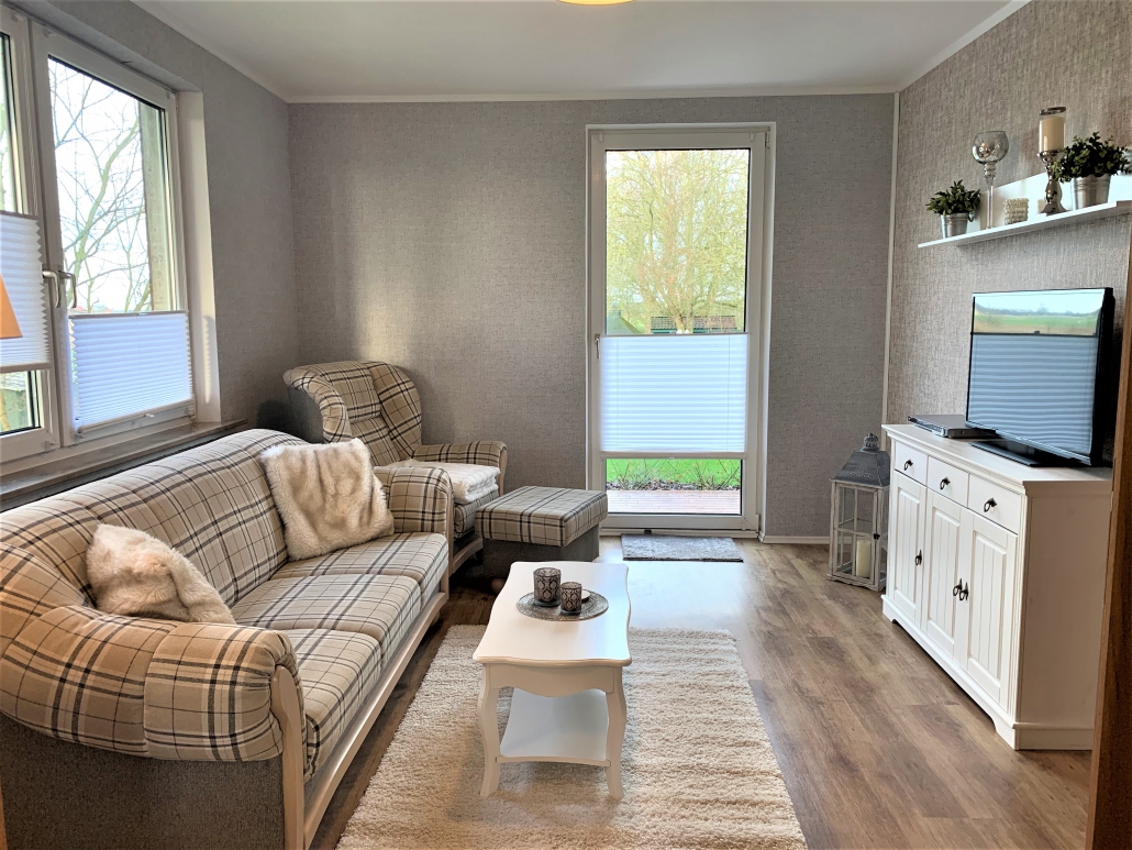 Monteurwohnung - Kaffeemaschine - Wilhelmshaven - Wohnzimmer mit Couch, Sessel und TV. Zugang zur Terrasse. - ANDY NORDSEE: 2 Schlafzimmerwohnung im Urlaubsparadies