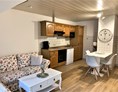 Monteurzimmer: Wohnküche mit Sofa und Essbereich - LÜTJE DEERN: 1 Schlafzimmerwohnung mit Platz für bis zu 3 Personen