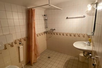 Monteurzimmer: Badezimmer mit ebenerdiger Dusche, Toilette, Handwaschbecken und Waschmaschine  - Svenja Wagner