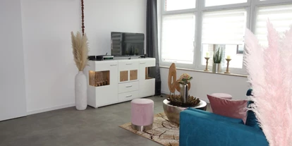 Monteurwohnung - Uslar - Wohnzimmer mit TV und Schlafcouch - Ferienwohnung Suite für Service Mitarbeiter, Monteure, komplett ausgestattet