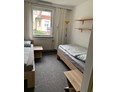 Monteurzimmer: Wohnbeispiel Einzelbettenanordnung mit Nachttisch und Lampen - Monteurunterkünfte im Hotelzimmercharakter