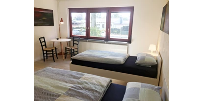 Monteurwohnung - Kaffeemaschine - Schleswig-Holstein - Eines unserer zwei Doppelzimmer mit Tisch und Stühlen im Nordhaus A7 bei Hamburg - Nordhaus A7 bei Hamburg