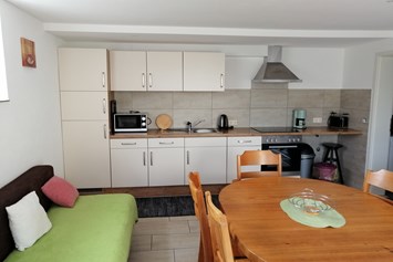 Monteurzimmer: neue Wohn-Essküche im EG mit Couch und TV - Gästehaus Lori