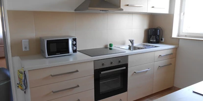 Monteurwohnung - Krautheim (Hohenlohekreis) - Küchenzeile links mit Kaffeemaschine und Mikrowelle - Gästehaus Lori