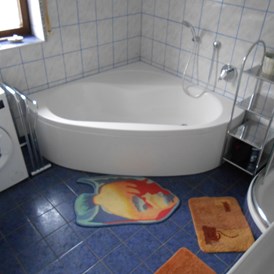 Monteurzimmer: Badezimmer mit Badewanne, Dusche, Waschbecken und Waschmaschine - Gästehaus Lori