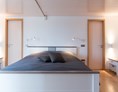Monteurzimmer: Schlafzimmer mit Doppelbett und begehbarem Kleiderschrank. Zugang zum Hauptbad mit Hauptdusche und Whirlpool. - Lara Loft