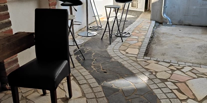 Monteurwohnung - Kühlschrank - Burgenland - Raucherbereich. Teilüberdachter Innenhof mit Stühlen, Bänken und Tischen. - Ferienwohnung Dorfleben, nahe Jennersdorf