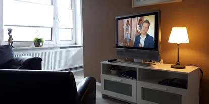 Monteurwohnung - Kaffeemaschine - Schleswig-Holstein - Wohnbereich, abgegrenzter Schlafbereich hinter der braunen Wand mit kleinem Schreibtisch - Privates Gästezimmer / Monteurzimmer mit Bad