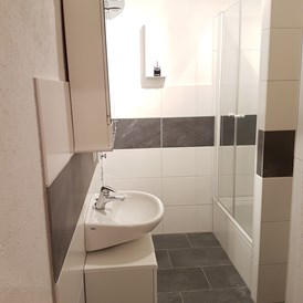 Monteurwohnung: Badezimmer mit Waschbecken, Dusche und WC - Monteurwohnung-Euskirchen - zentrale Lage mit gehobenem Stil