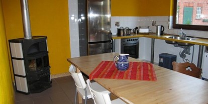 Monteurwohnung - PLZ 27432 (Deutschland) - Die große Küche der Ferienwohnung mit Kaminofen, großem Kühlschrank und Geschirrspüler. - Ferienwohnung Animal Farm