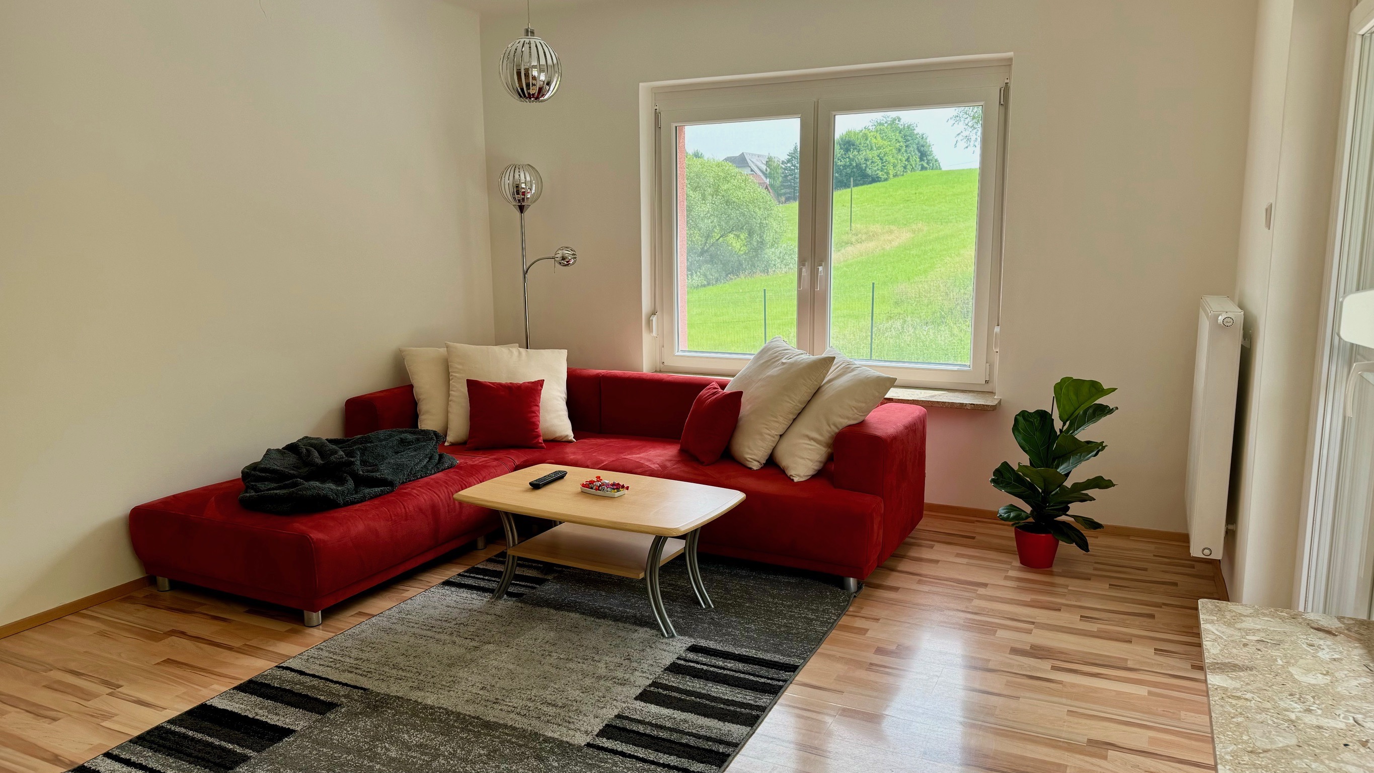 Monteurzimmer: geräumiges Wohnzimmer mit Couch, Tisch, Fernseher und Büchern - Geräumiges Wohnhaus in Wildon, südlich von Graz