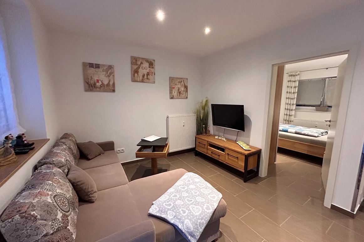 Monteurzimmer: Wohnzimmer mit TV und Schlafsofa - Ferienwohnung Hofblick