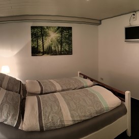 Monteurzimmer: Schlafzimmer mit Doppelbett, Kleiderschränken und Fernseher. - Tatjana Tillmann