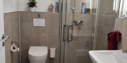 Monteurwohnung - PLZ 75433 (Deutschland) - Gästezimmer La Siesta - moderne Badezimmer mit bodengleiche Dusche - Wanduhr, Abluftsystem, Haartrockner und kostenlose Pflegeprodukte - Gästezimmer La Siesta