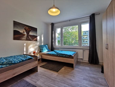 Monteurzimmer: Gemütliches Schlafzimmer mit zwei Einzelbetten sowie zwei Schränken. - flex living -  Monteurwohnungen in Freiberg