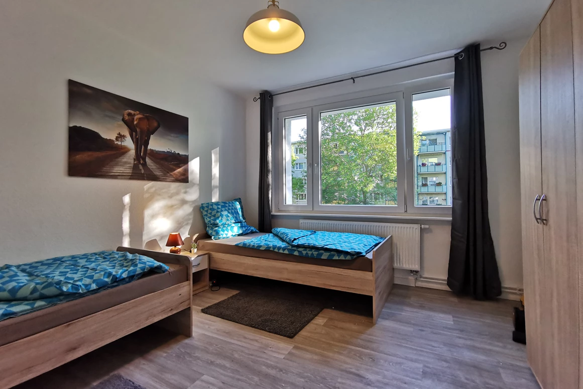 Monteurzimmer: Gemütliches Schlafzimmer mit zwei Einzelbetten sowie zwei Schränken. - flex living -  Monteurwohnungen in Freiberg