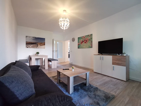Monteurzimmer: Gemütliches Wohnzimmer zum Wohlfühlen mit Essbereich, Couch, TV & Balkon. - flex living -  Monteurwohnungen in Freiberg