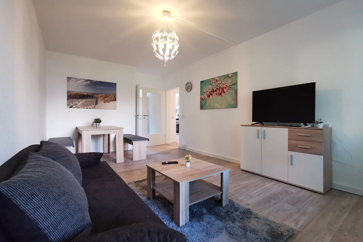Monteurzimmer: Gemütliches Wohnzimmer zum Wohlfühlen mit Essbereich, Couch, TV & Balkon. - flex living -  Monteurwohnungen in Freiberg