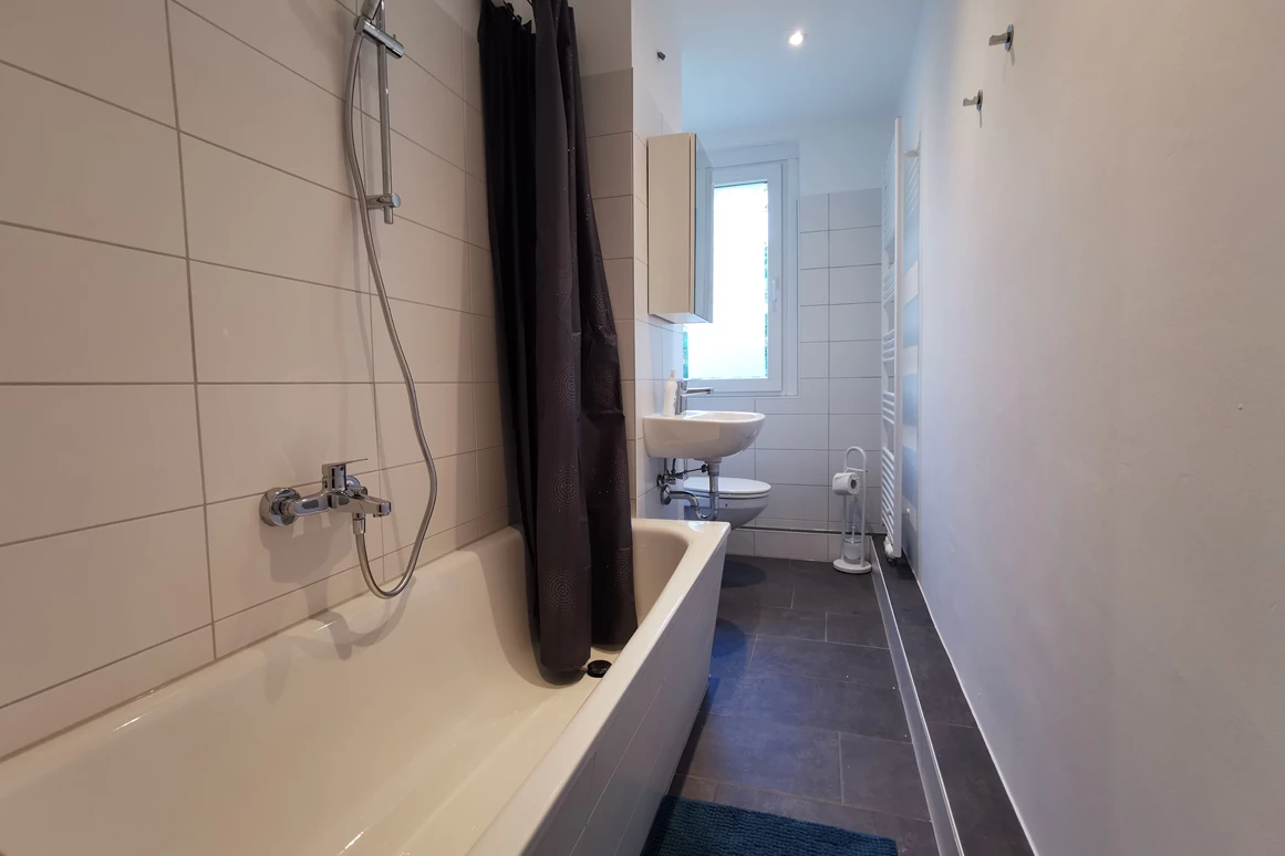 Monteurzimmer: Helles Badezimmer mit Badewanne zum Baden oder Duschen. - flex living -  Monteurwohnungen in Freiberg