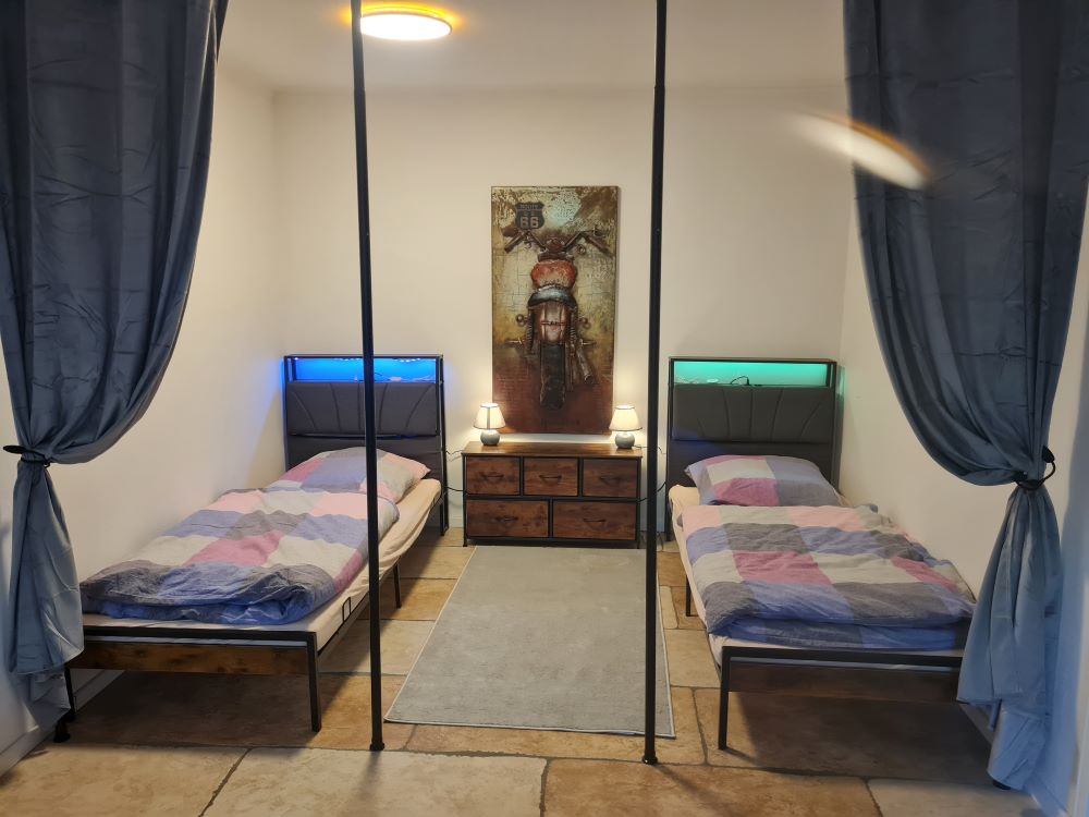 Monteurwohnung - Zimmertyp: Mehrbettzimmer - Hessen - Schlafbereich im Wohnzimmer mit zwei getrennten Betten und Sichtschutz zum Wohnbereich - Monteurwohnung, Monteurunterkunft - Nähe Frankfurt/Hanau
